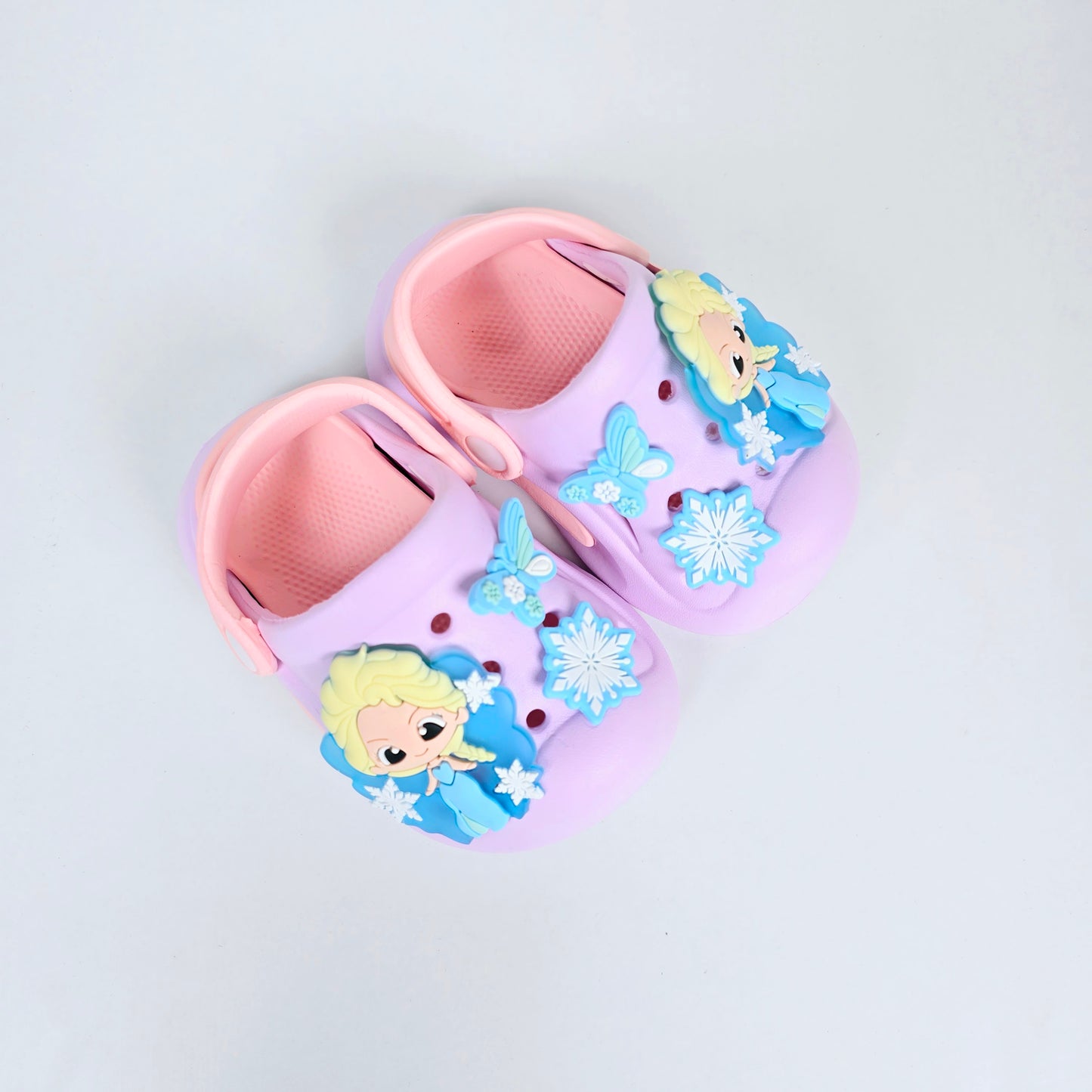 lavender, pink and peach crocs with cartoon and butterfly pattern